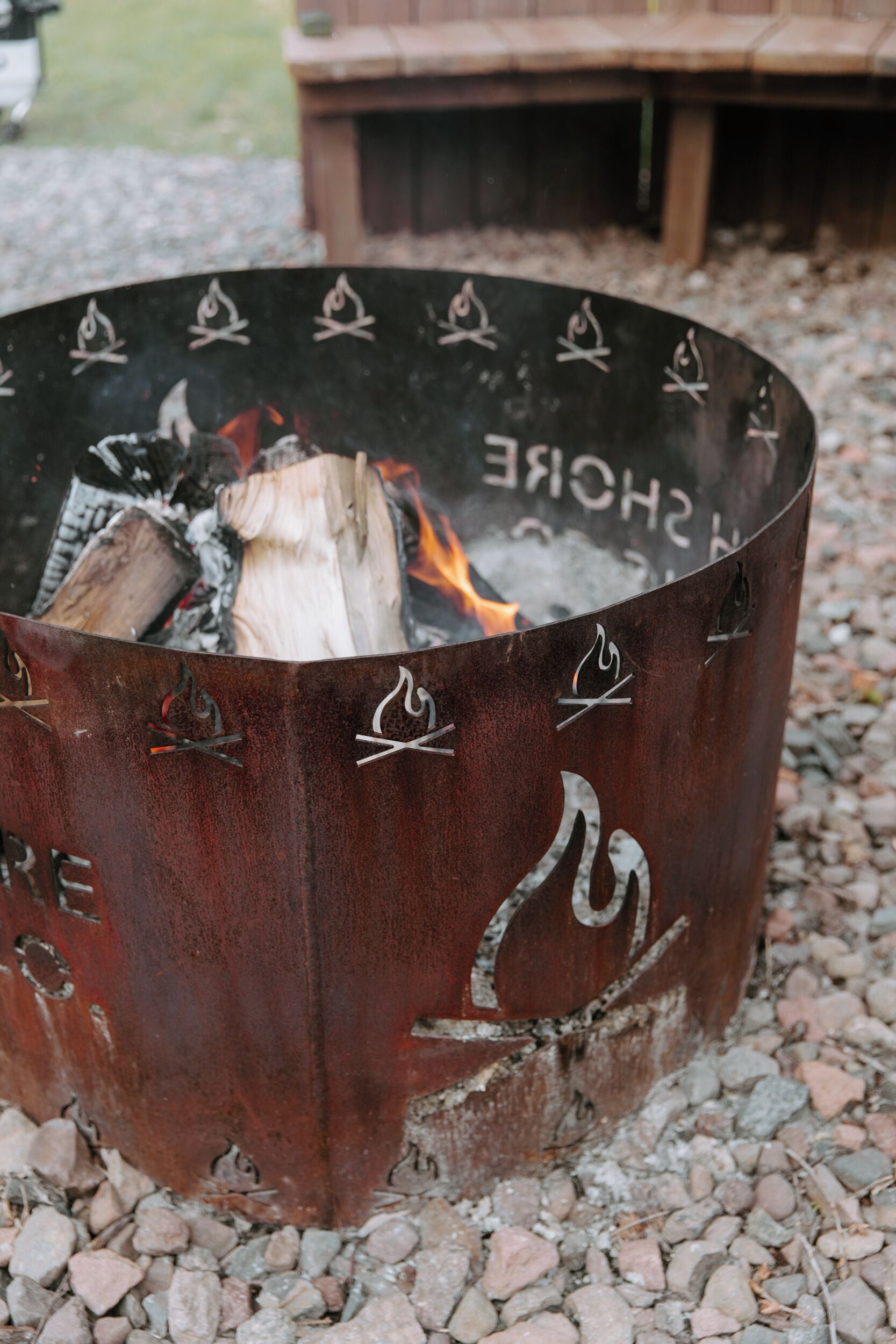 A metal fire pit with decorative symbols and the words "SHOWER" and "CHURCH" on it.