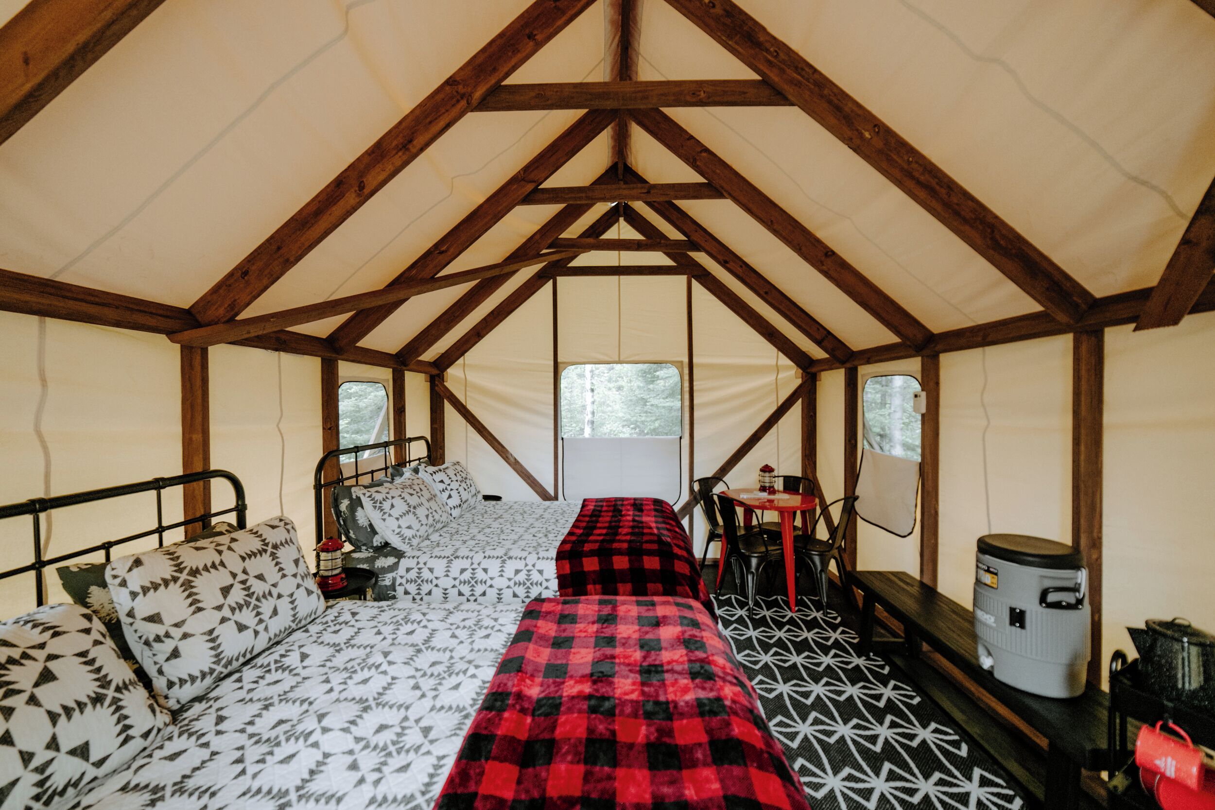 Een tent met een bed, een tafel en een stoel.