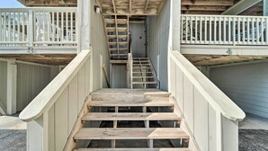 Eine Holztreppe führt zu einem Balkon mit weißen Geländern.