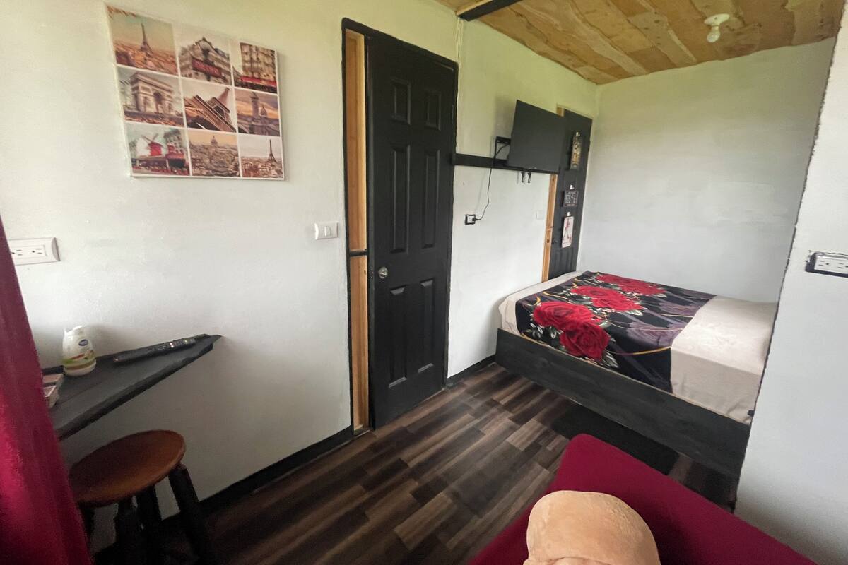 A small, compact room with a bunk bed, a desk, and a chair.