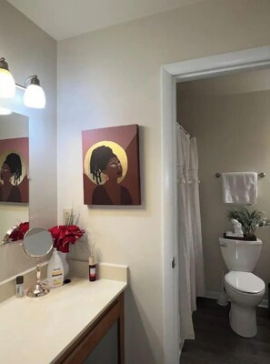 Tina con regadera, toallas, papel de baño