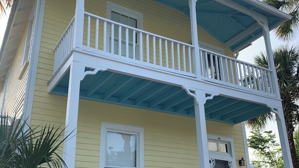 A two-story house with a yellow facade, white trim, and a blue roof. - Historic Murphy's House (St. Augustine)