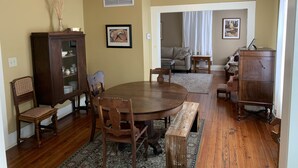 A dining area with a round table, wooden chairs, a cabinet, and a chandelier. - Historic Murphy's House (St. Augustine)