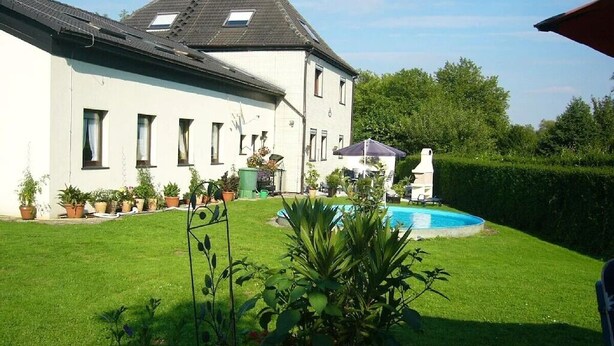 A house with a swimming pool, a well-maintained lawn, and several potted plants. - Fair guests Harz visitors Bike - and Outdoorpark Bad Salzdetfurth (Bockenem)