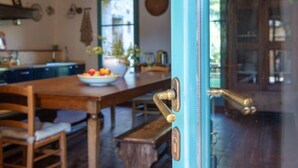 A kitchen with a wooden table, a bowl of fruit, and a vase with flowers. - Podere Vignali by Interhome (Pari)