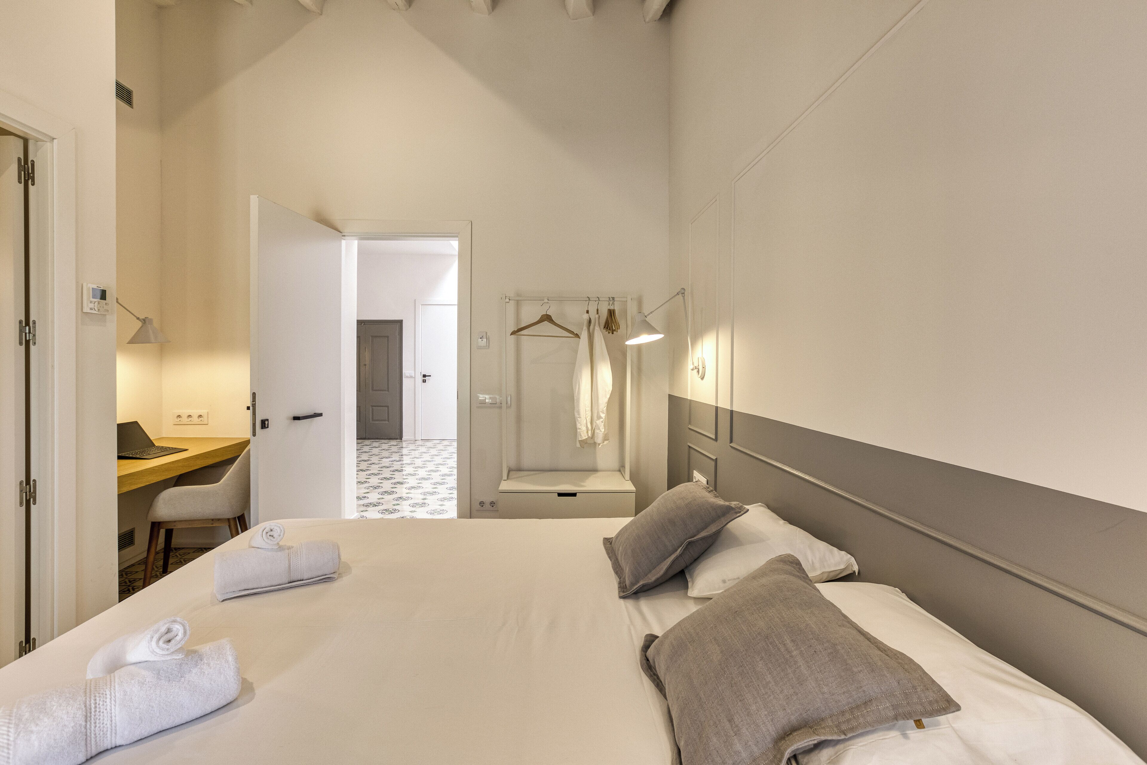 A hotel room with a bed, a desk, and a bathroom.