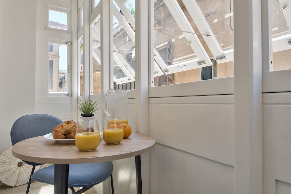 Een ontbijttafel met croissants, sinaasappelsap en een plant in pot.
