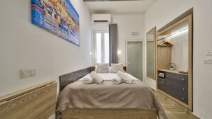 Een slaapkamer met een houten bed, een grote spiegel, een garderobe en een schilderij aan de muur.