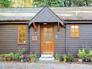 Une petite maison en bois dotée d’une porte centrale en bois, de deux fenêtres de chaque côté et d’une enseigne indiquant qu’il s’agit du poste de péage d’un pont.