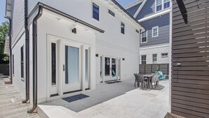 A modern house with a patio area, a dining set, and a wooden fence. - Old Seagrove "Thyme by the Sea" |3BR| 2 Kings| Sleeps 9| 250ft from Beach! (Santa Rosa Beach)