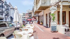 Eine Straße mit Außenbestuhlung und einem Café namens "la Crema".