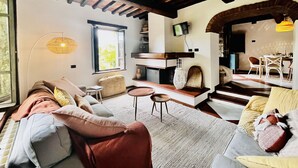 A cozy living room with a sofa, a coffee table, and a dining area with chairs and a table.