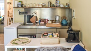A compact kitchen with a sink, a coffee maker, and a small countertop.