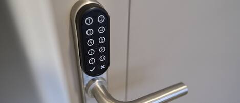 A modern door lock with a numeric keypad and a lever handle.