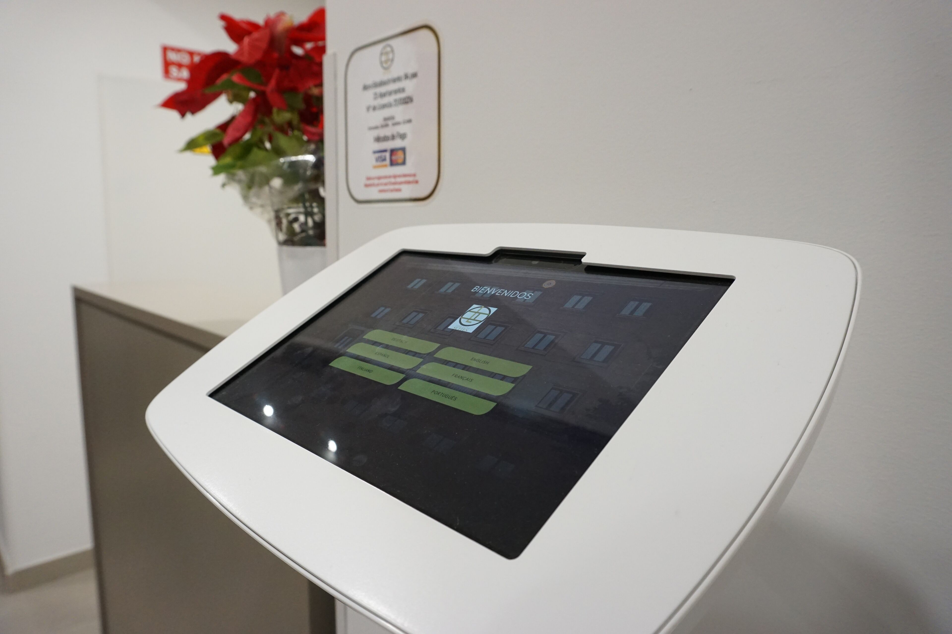 Un kiosque numérique doté d’un écran tactile, d’un panneau d’affichage et d’une plante en pot.