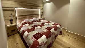 Una camera da letto con una testiera in legno, una coperta trapuntata e un comodino con una lampada.