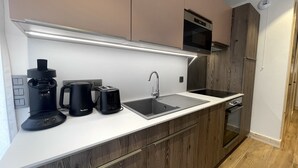 Una cucina moderna dotata di macchina da caffè integrata, tostapane e lavello.
