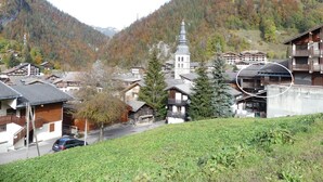 Un edificio in legno tradizionale con un tetto spiovente, immerso in un paesaggio montuoso.