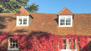 A two-story house with a brick roof, two windows, and ivy covering the lower part. - 1 bedroom accommodation in Fernhurst (Fernhurst)