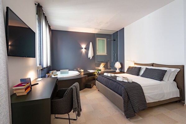 A modern hotel room with a bed, desk, and chair.