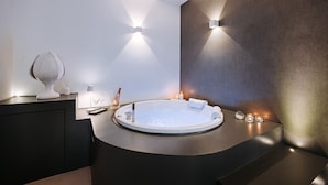 A modern bathroom with a freestanding bathtub, a dark vanity, and wall-mounted sconces. - Suite1212 Rattazzi (Monopoli)