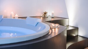 A modern spa area with a hot tub, candles, and a minimalist design. - Suite1212 Rattazzi (Monopoli)