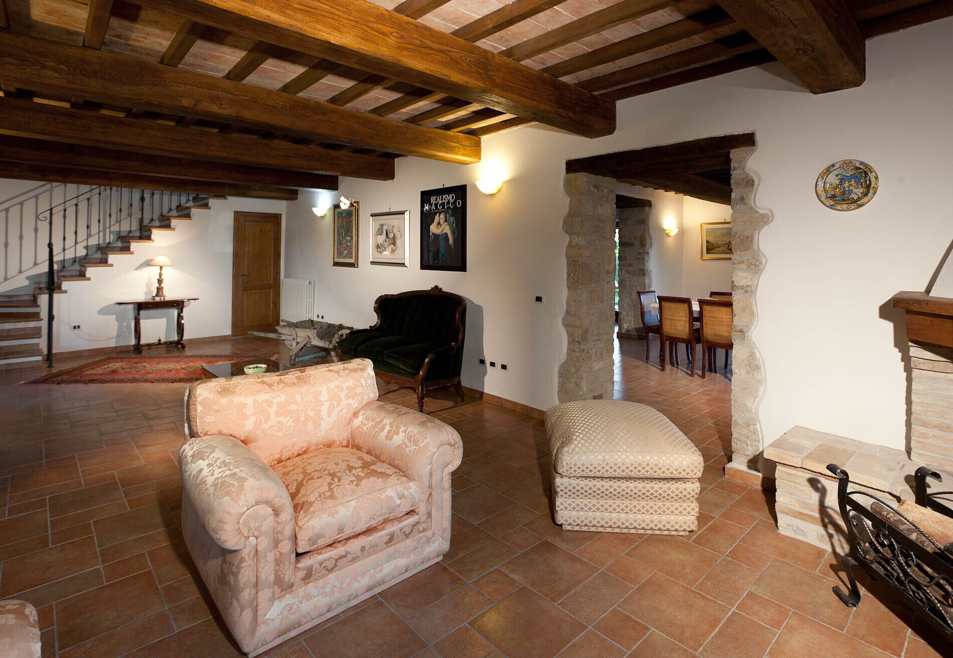 Un salón comedor amplio con escalera y chimenea.