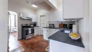 Una cocina moderna con armarios blancos, encimera negra y horno empotrado.