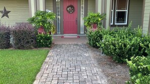 A residential house with a red front door, a star decoration, and a brick pathway leading to the entrance. - Farm to Beach in 15 Minutes (Panama City Beach)