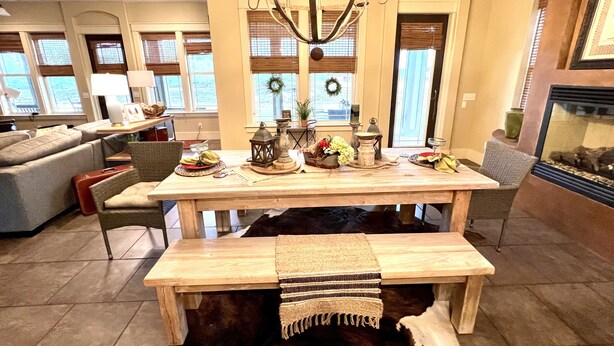 A dining area with a wooden table, benches, and a chandelier. - Farm to Beach in 15 Minutes (Panama City Beach)