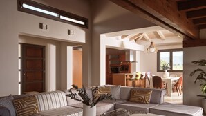 Amplia sala de estar con un sofá modular, una mesa de centro y un comedor con sillas y una mesa.