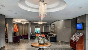 A lobby with a round table, seating area, and a television on the wall. - Mountain Getaway for Families &Groups WATERSLIDE!! (Canmore)