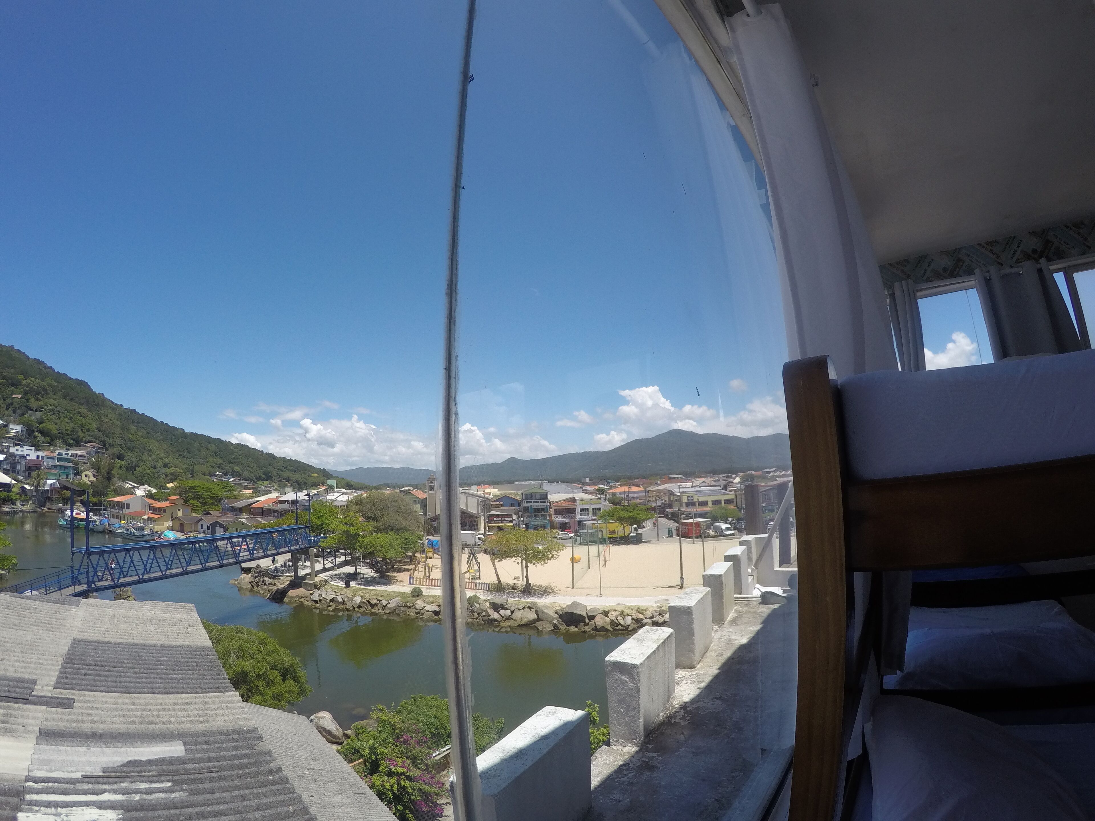 Une chambre avec vue sur une ville, un pont et une étendue d’eau.