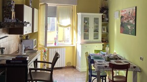 A cozy kitchen with wooden beams, a dining area with chairs, and a window letting in natural light. - The most glamorous lounge in downtown: romantic sensory and rock! (Bergamo)