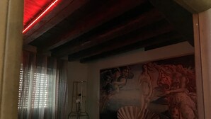 A room with a red bed, a large mural, a metal shelf, and a red light fixture. - The most glamorous lounge in downtown: romantic sensory and rock! (Bergamo)