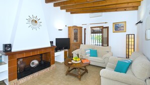 A living room with a fireplace, a sofa, a coffee table, and a television. - Bacana, Finca 5StarsHome Mallorca (Puerto Pollensa)