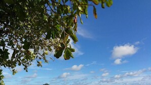 A beach with clear skies, waves, and distant islands. - Moonshine Inn — Pool Level Suite , Moonshine Inn -- Pool-Level 2BR Suite (Quepos)