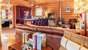 A cozy log cabin interior with a living room, kitchen, and dining area. - Grebe Lodge (Lodge 6) (Frettenham)