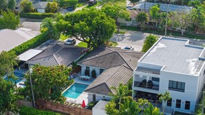 Un barrio residencial con varias casas, una piscina y un patio cercado.