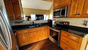 A kitchen with wooden cabinets, a stainless steel refrigerator, a microwave, and an oven. - Almost Heaven - Mountain views beyond compare! (Hiawassee)