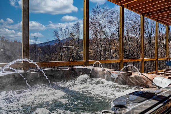Hot tub on deck outside of indoor pool.