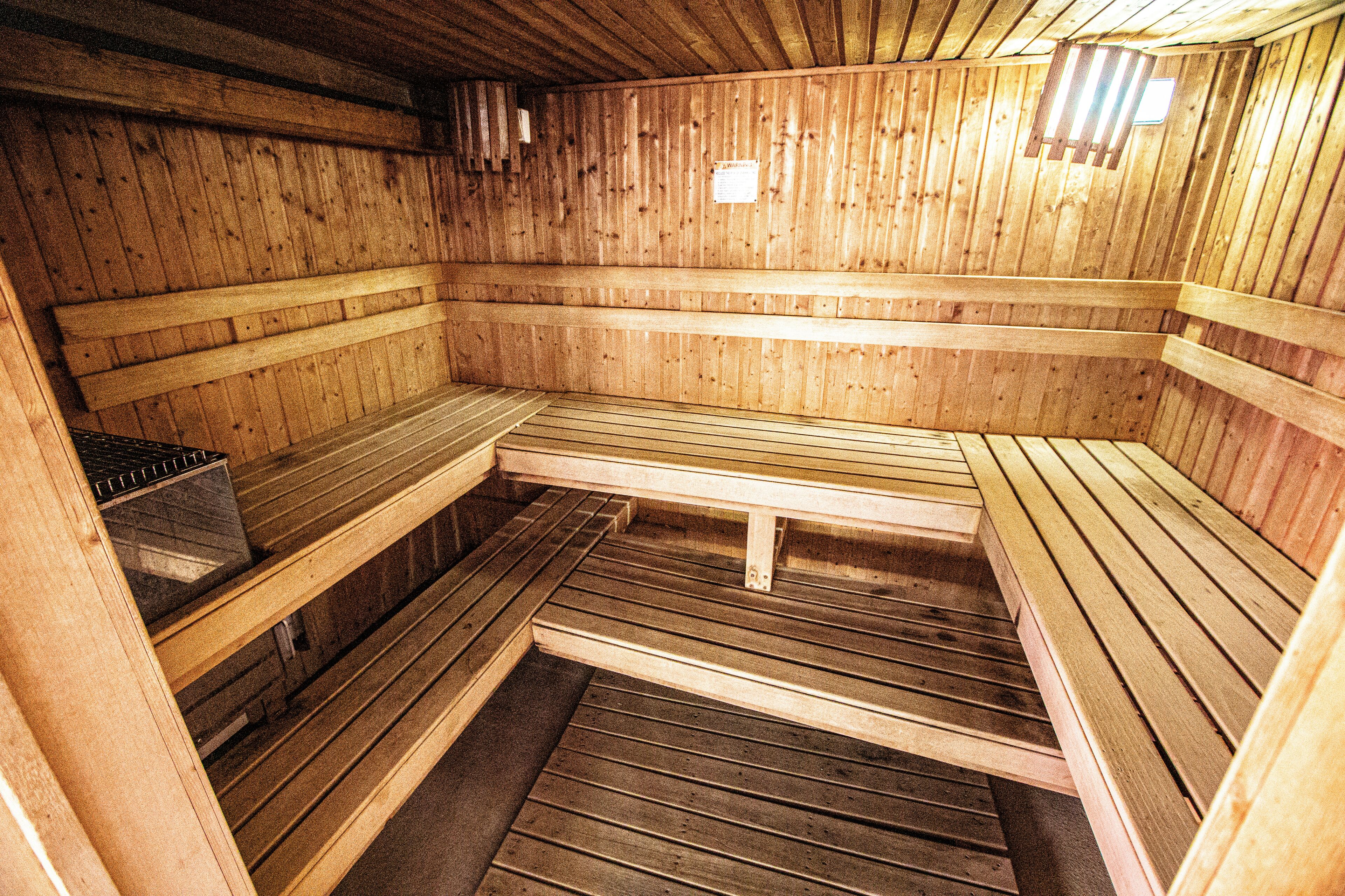 A sauna with wooden benches and a bench in the center.