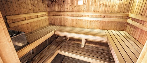 A sauna with wooden benches and a bench in the center.
