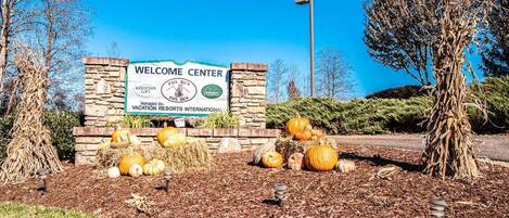 A welcome center with a stone wall and a signboard.