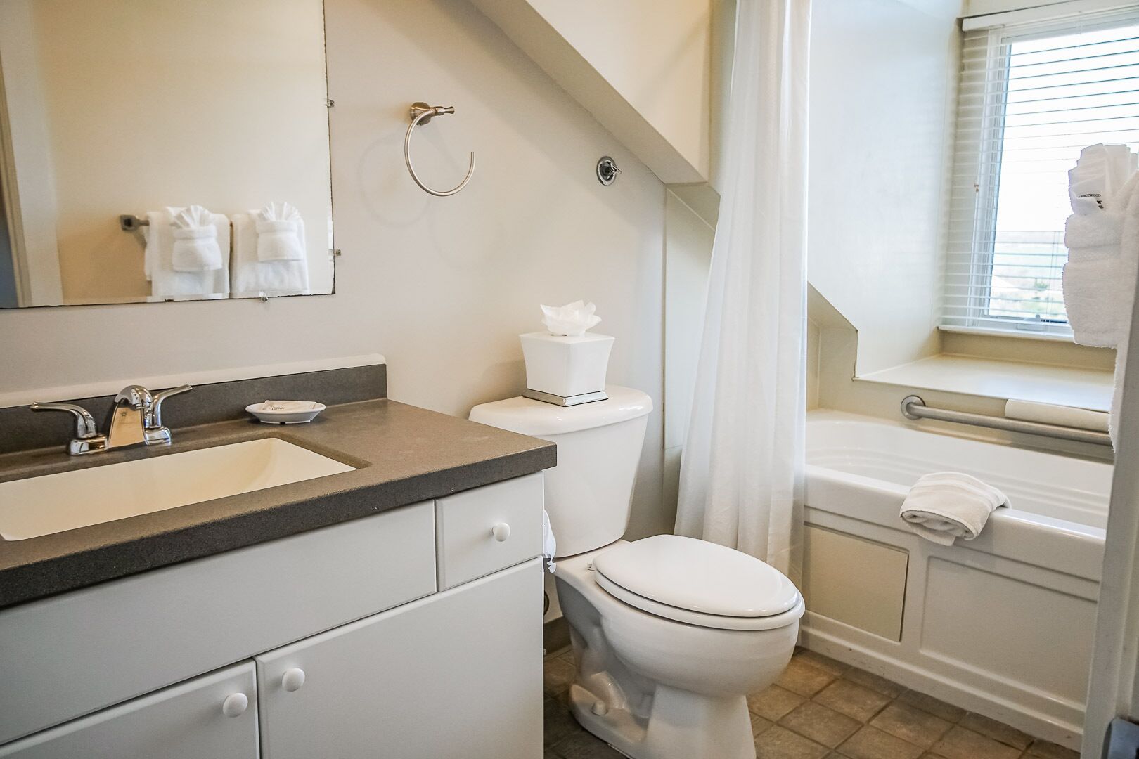 A modern bathroom with a sink, toilet, and bathtub.