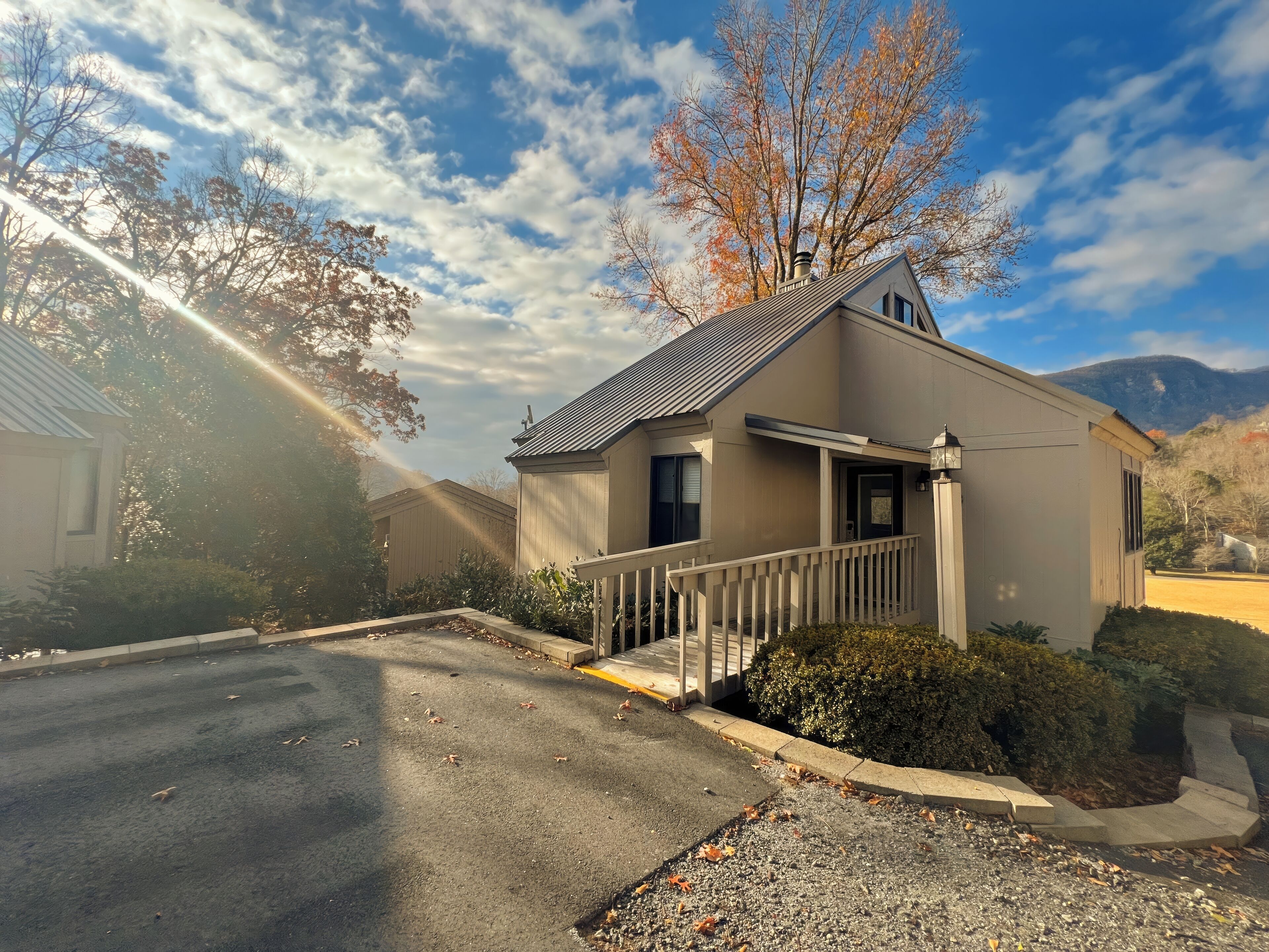 A residential house with a front porch, a garage, and a driveway.
