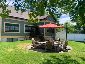 A house with a patio area featuring outdoor furniture and a grill.