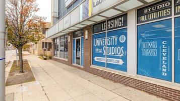 A building with large blue windows advertising 'University Studios' and 'Downtown Cleveland'.