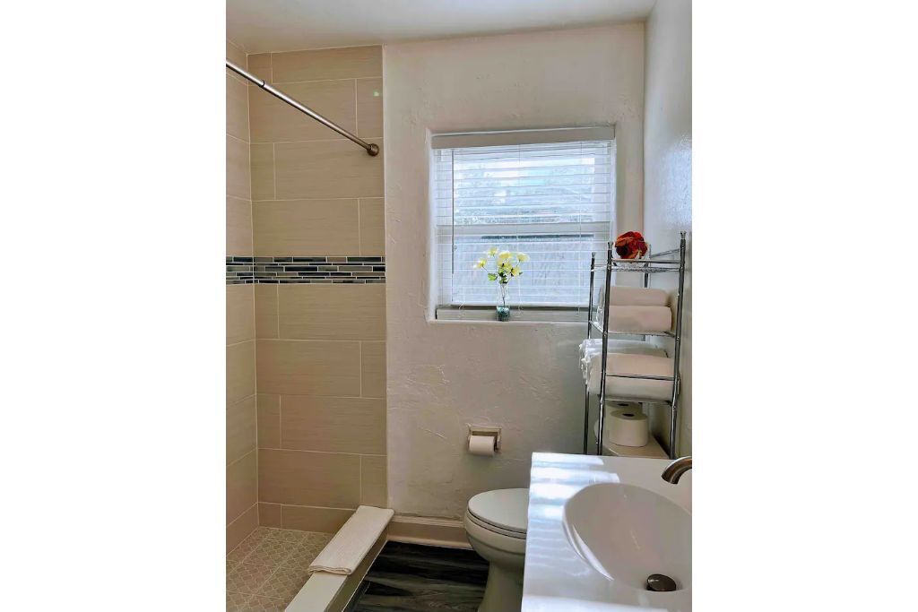 A bathroom with a shower, toilet, and sink.