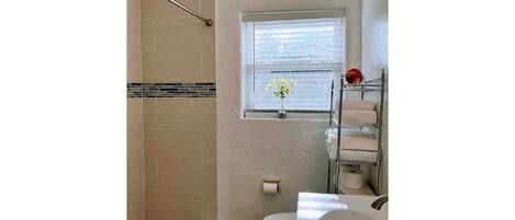 A bathroom with a shower, toilet, and sink.
